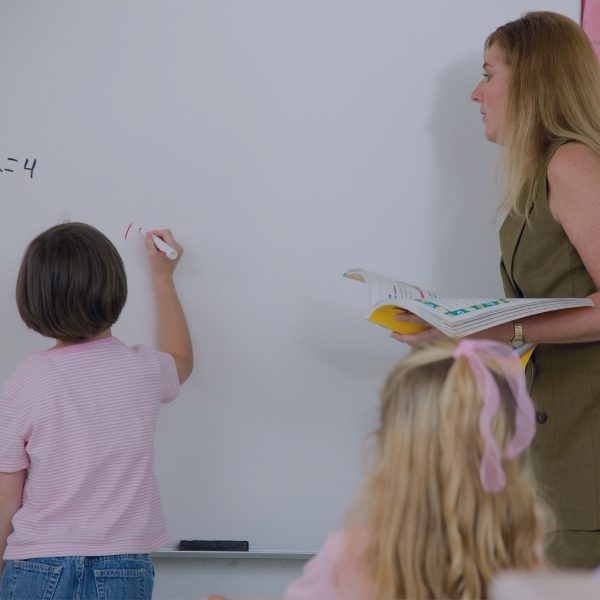 child writing on the board in class