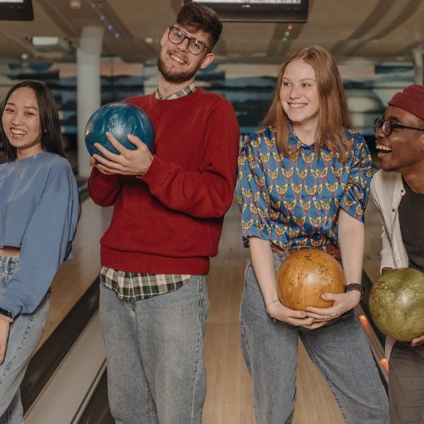 diverse group of young adults bowling