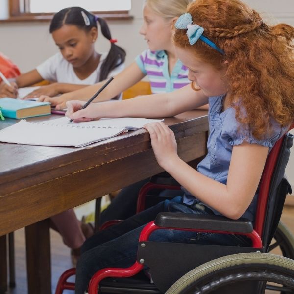 red head girl in wheelchair doing school work